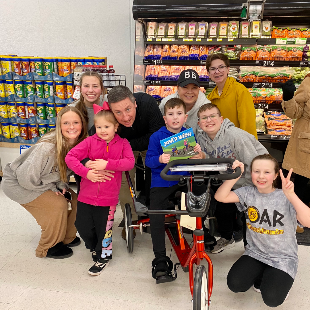 Moby and his family with his new specialized bike and a copy of Joni's Wish